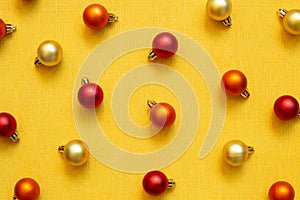 Christmas ornament. red orange gold baubles on yellow fabric texture background