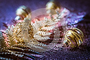 Christmas ornaments and balls with glitter background in violet and golden tones