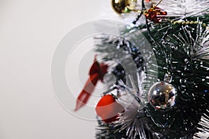 Green Christmas tree with red and gold and silver ornaments.