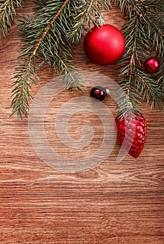 Christmas ornaments and fir tree branch on a rustic wooden background. Xmas card. Happy New Year. Top view