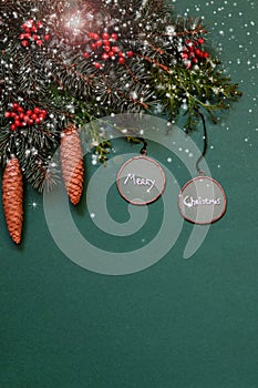 Christmas ornaments, fir tree branches, cones on green background with painted snow.Vertical. Flat lay