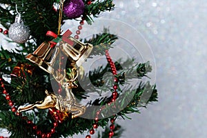 Christmas ornaments hanging on christmas tree over white giltter background