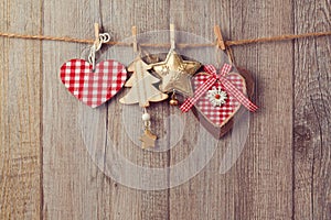 Christmas ornaments hanging on string over wooden background