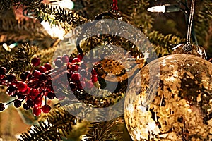 Christmas ornaments on a lit fur tree.