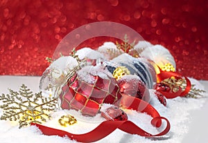 Christmas ornaments in the snow over red background
