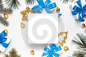 Christmas ornaments. White gift box with blue ribbon, New Year balls and Christmas tree in xmas composition on white background