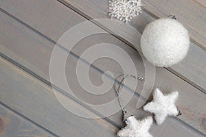 Christmas ornaments in white on a light gray wooden background. New Year`s accessories. View from above.