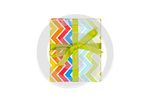 Christmas or other holiday handmade present in colored paper with green ribbon. Isolated on white background, top view.