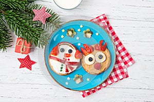 Christmas pancakes in a shape of deer and snowman made of fresh fruits and berries and glass of milk. Healthy food for kids ideas