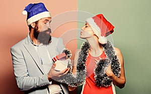 Christmas party office. Happy man and woman wear santa hats. Cheerful couple celebrate new year. Giving gift. Festive