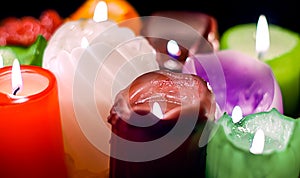 Christmas party, romantic date concept: colorful burning candles on dark background