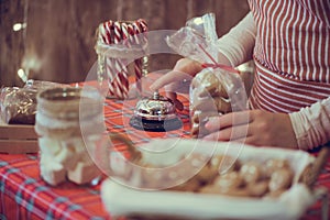 Christmas pastry shop. Woman seller, waitress ringing bell to warn that home made gingerbread cookies is ready. Selling