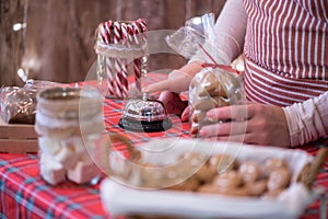 Christmas pastry shop. Woman seller, waitress ringing bell to warn that home made gingerbread cookies is ready. Selling