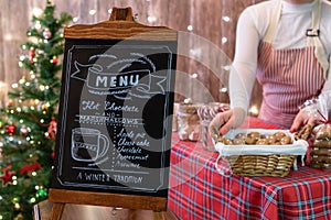 Christmas pastry shop . Woman seller, waitress selling gingerbread, marshmallows, cookies, sweets and hot chocolate