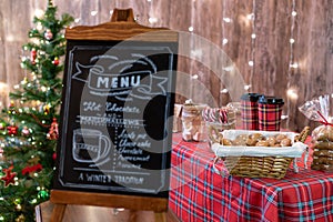 Christmas pastry shop . Woman seller, waitress selling gingerbread, marshmallows, cookies, sweets and hot chocolate