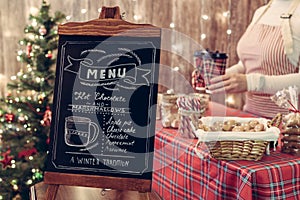 Christmas pastry shop . Woman seller, waitress selling gingerbread, marshmallows, cookies, sweets and hot chocolate in a small