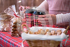 Christmas pastry shop. Woman seller, waitress selling hot chocolate in paper cup, gingerbread, marshmallows, cookies, sweets