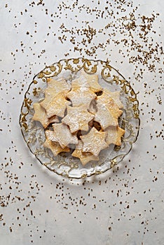 Christmas pastry stars on delicate gray table. Golden adornment