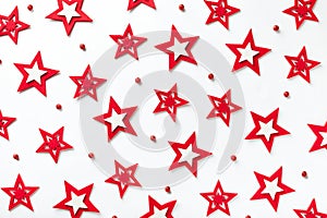 Christmas pattern of red stars on a white wooden background.