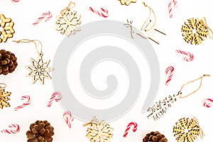 Christmas pattern with wooden tree decoration, snowflakes and pine cones on white. Flat lay, top view. Holiday frame concept.