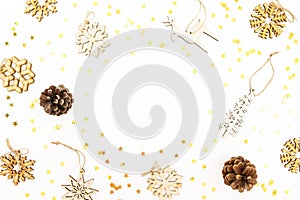 Christmas pattern with wooden tree decoration, snowflakes and pine cones on white. Flat lay, top view. Winter festive frame concep