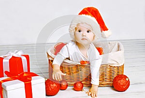 Christmas and people concept - charming baby with gifts