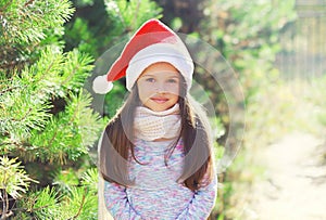 Christmas and people concept - little girl child in santa red hat