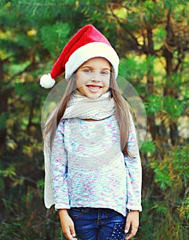 Christmas and people concept - smiling little girl child in santa red hat