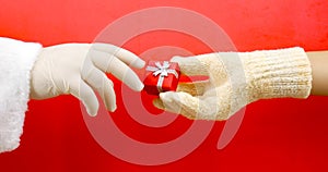 At Christmas, people give each other gifts. On a red background, a man gives a gift in a red box with a silver ribbon to