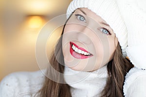 Christmas, people and winter holiday concept. Happy smiling woman wearing white knitted hat as closeup face xmas