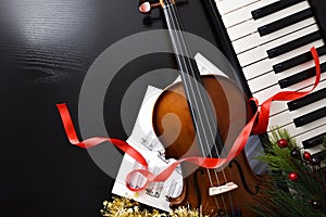 Christmas performance concept with violin and piano on black table