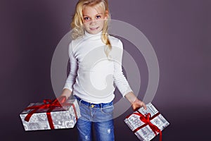 Christmas photo of cute little blond girl with presents