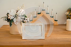 Christmas photo frame mock up template with decoration on wooden table.