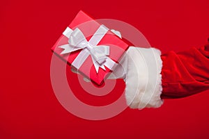 Christmas Photo of Santa Claus gloved hand with red giftbox