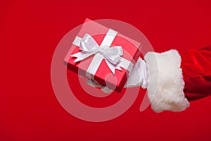 Christmas Photo of Santa Claus gloved hand with red giftbox