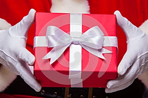 Christmas Photo of Santa Claus gloved hand with red giftbox