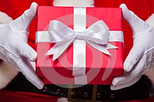 Christmas Photo of Santa Claus gloved hand with red giftbox