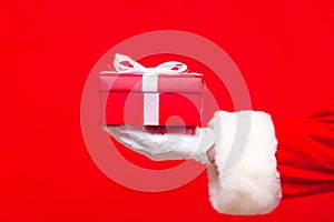 Christmas Photo of Santa Claus gloved hand with red giftbox photo