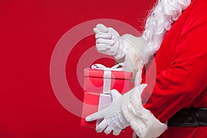 Christmas Photo of Santa Claus gloved hand with red giftbox. no fig