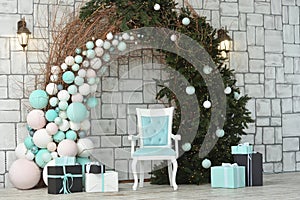 Christmas photo zone. Arch from a Christmas tree, balls, garlands, New Year`s decorations. Gift boxes, empty blue chair