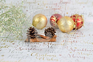 Christmas photography of flowers with glitter pine cones and baubles on xmas wrapping paper background