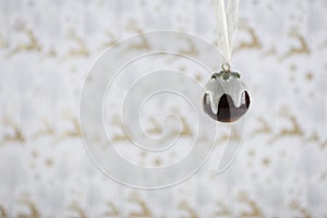 Christmas photography image of christmas decoration hanging up of xmas pudding cream holly with reindeer wrapping paper background