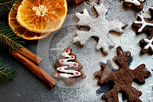 Christmas picture. Chocolate gingerbread Christmas trees and snowflakes sprinkled with flour on a dark background