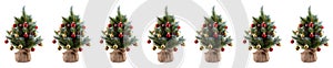 Christmas pine trees in pots wrapped in cloth and decorated with colorful balls, cones, red berries. Tips of pine branches covered