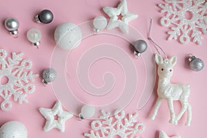 Christmas pink and white decorations on a pastel pink background with space for text. Layout of a postcar