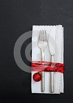 Christmas place setting on black background, vertical top view