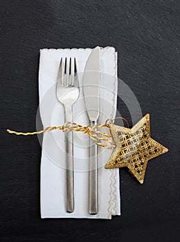 Christmas place setting on black background, vertical top view