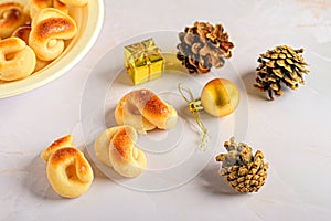 a christmas plate containing donuts and small ornaments, pine cones and a gift