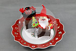 A Christmas plate with sweets and figures of Krampus and Santa Claus or Nicholas