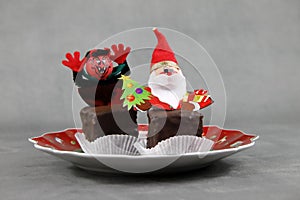 A Christmas plate with sweets and figures of Krampus and Santa Claus or Nicholas